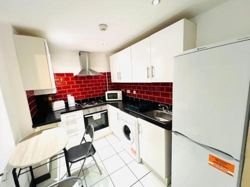 a kitchen with white cabinets and a table with chairs at Excellent Two Bedroom Flat In Central London in London