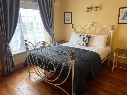 a bedroom with a bed and a window at St Martin's, Rosslare Harbour Guest Accommodation in Rosslare