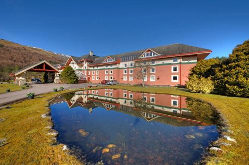 a building with a reflection in a body of water at Muthu Ben Doran Hotel in Tyndrum