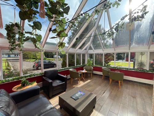 a conservatory with a lot of windows and plants at Muthu Ben Doran Hotel in Tyndrum