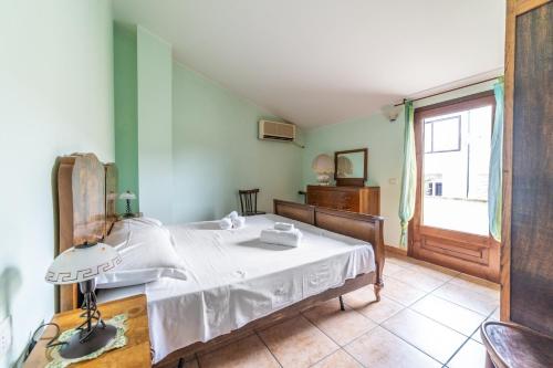 a bedroom with a bed with a white sheets and a window at Sa Pedrera in Putzu Idu