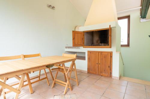 a dining room with a table and a tv at Sa Pedrera in Putzu Idu