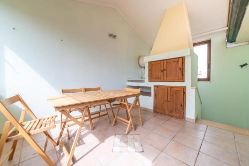 a kitchen with a wooden table and chairs at Sa Pedrera in Putzu Idu