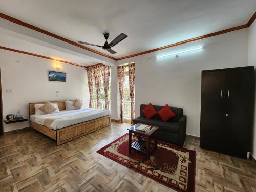 - une chambre avec un lit, un canapé et une télévision dans l'établissement Mountain Golden Ray, à Mukteswar