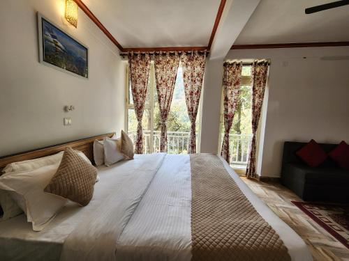 - une chambre avec un grand lit et une grande fenêtre dans l'établissement Mountain Golden Ray, à Mukteswar