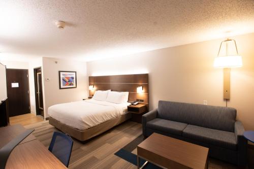 um quarto de hotel com uma cama e um sofá em Holiday Inn Express Houghton-Keweenaw, an IHG Hotel em Houghton