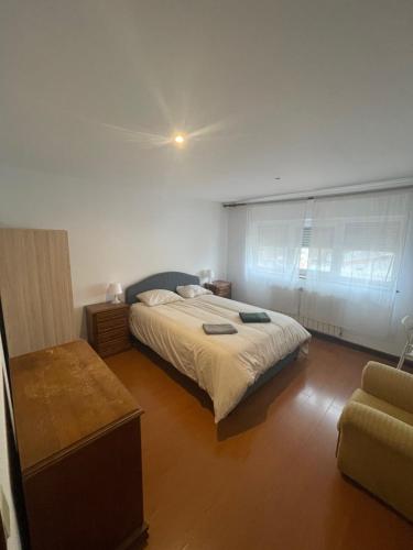Un dormitorio con una cama y una silla dentro. en Picadeiro A, en Bragança