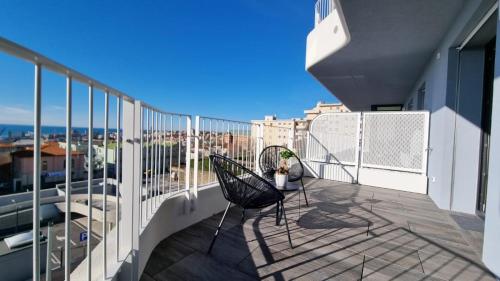 balkon z 2 krzesłami i widokiem na miasto w obiekcie Le Terrazze Sul Golfo w Trieście