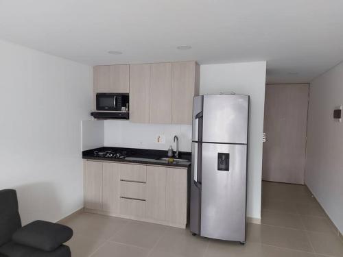 a kitchen with a stainless steel refrigerator in a room at El EmAnJe Sabaneta in Sabaneta