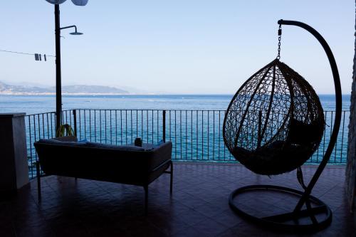 a room with a swing and a chair and the ocean at Villa Venere - Amalfi Coast - Private Sea Access in Cetara
