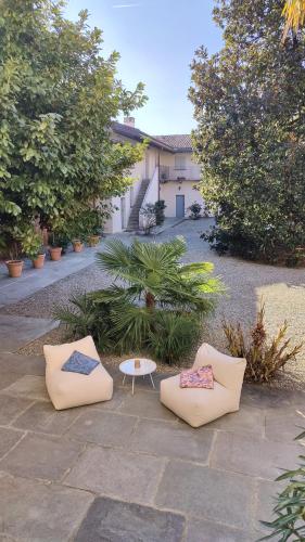 two chairs and a table in a courtyard at Dandelion Como Suites & Park in Villa Guardia