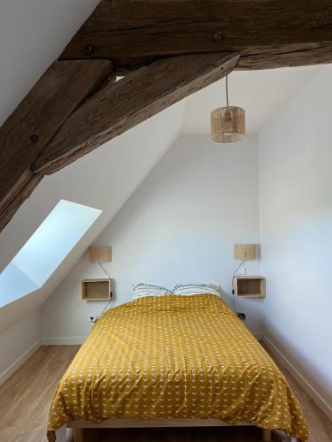 - une chambre mansardée avec un lit jaune dans l'établissement Jolie maison de campagne au cœur du Brionnais, à Saint-Laurent-en-Brionnais