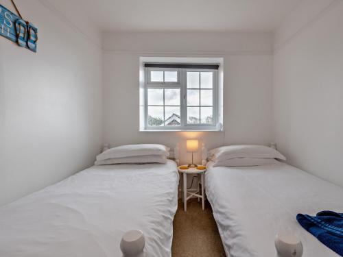 2 camas individuales en una habitación con ventana en 4 Bed in Westward Ho 46840, en Westward Ho