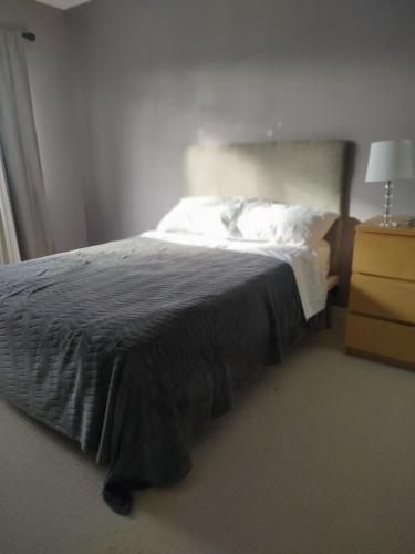 1 dormitorio con 1 cama con manta negra y vestidor en Double bed Suite - Very close to the Falls, Casinos and Marineland en Niagara Falls