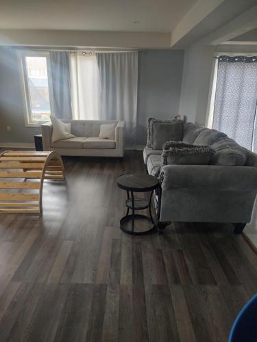 ein Wohnzimmer mit einem Sofa und einem Tisch in der Unterkunft Double bed Suite - Very close to the Falls, Casinos and Marineland in Niagara Falls