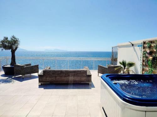 un patio con bañera de hidromasaje y vistas al océano en THOMAS SEA VIEW, en Torre del Greco