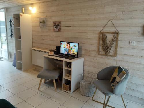 Zimmer mit einem Schreibtisch, einem Computer und einem Stuhl in der Unterkunft Maison indépendante parfaite pour tous voyageurs. in Le Landreau