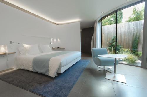 a bedroom with a bed and a table and a chair at MAISON KERVARREC - Rennes - Saint-Grégoire in Saint-Grégoire