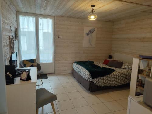 ein Schlafzimmer mit einem Bett und einem Sofa in einem Zimmer in der Unterkunft Maison indépendante parfaite pour tous voyageurs. in Le Landreau