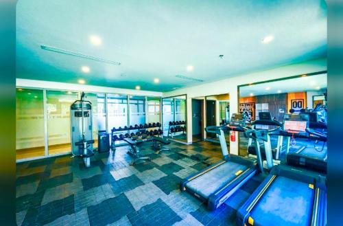 een fitnessruimte met een rij loopbanden en machines bij Executive Condo unit @ the Palladium in Iloilo City