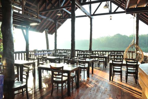 a dining room with tables and chairs in a building at Borneo Natural Sukau Bilit Resort in Bilit
