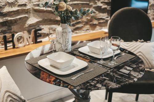 una mesa con platos y vasos y un jarrón en Suit'Home Commerce, en Angers