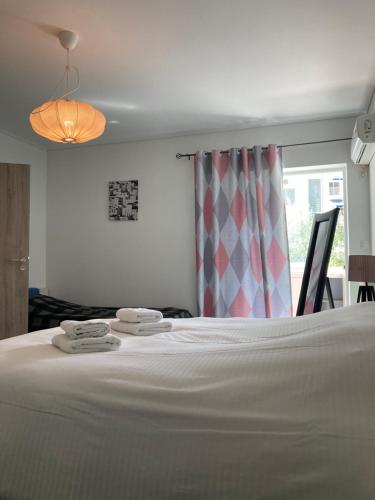 1 dormitorio con 1 cama blanca y 2 toallas en Mimoza's Apartment, en Atenas