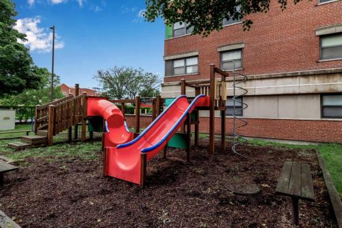 a playground with a slide in front of a building at Central Downtown Living in Buffalo