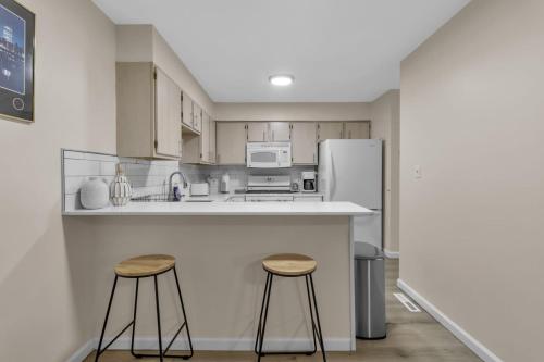 a kitchen with two stools and a refrigerator at Central Downtown Living in Buffalo