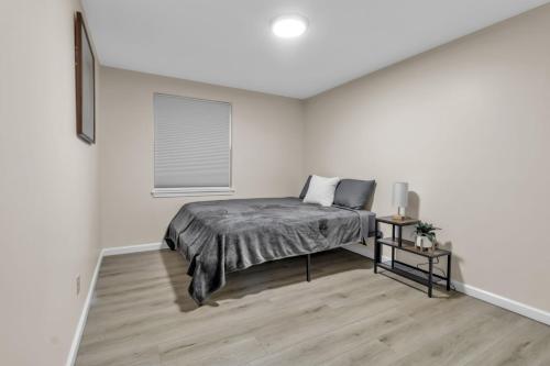a bedroom with a bed in a white room at Central Downtown Living in Buffalo