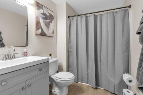 een badkamer met een wit toilet en een douchegordijn bij Central Downtown Living in Buffalo