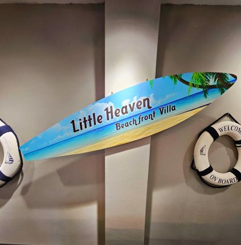 a surfboard on display on a wall with aogie board at Little Heaven by Sky Hive, A Beach Front Bungalow in Tanjung Bungah