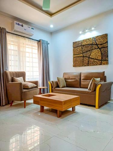 a living room with two couches and a coffee table at Box 55-Moon Apartment in Enugu