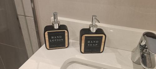 two bottles of hand soap sitting on a counter at Menlyn Maine Trilogy Apartment 1010 in Pretoria