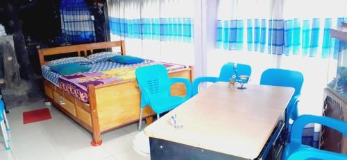 Habitación con cama, sillas y mesa. en Home Stay Nawalapitiya en Nawalapitiya