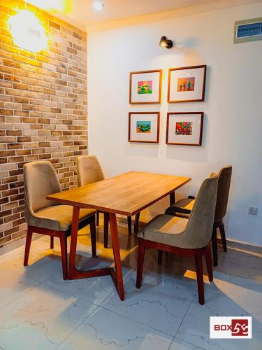 a wooden table and chairs in a room at Box 55-Moon Apartment in Enugu