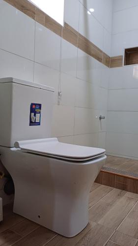 ein weißes WC im Bad mit Dusche in der Unterkunft Box 55-Moon Apartment in Enugu