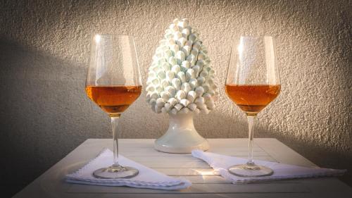 dois copos de vinho e um vaso com uma flor em MaNanna B&B em Marzamemi