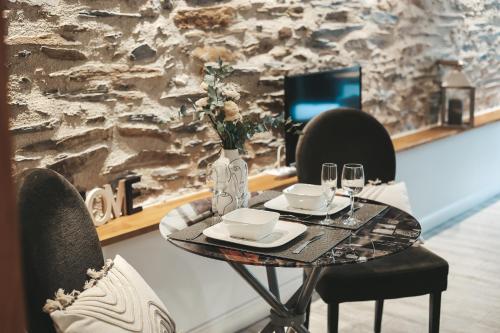 une table avec deux chaises et un vase avec des fleurs dans l'établissement Suit'Home Commerce, à Angers