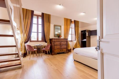 um quarto com uma cama, uma mesa e cadeiras em La Torre Rooms em Spoleto