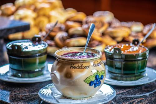 a table topped with three different colored drinks on plates at Hotel Kapitany Wellness in Sümeg