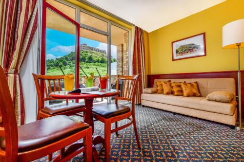 a living room with a couch and a table at Hotel Kapitany Wellness in Sümeg