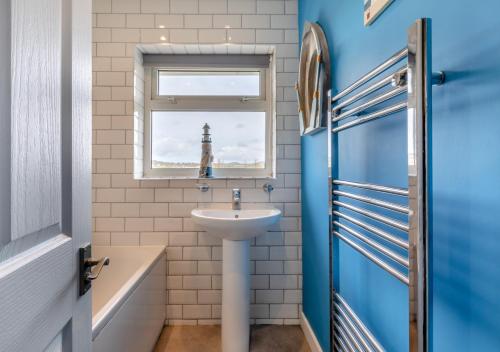 a bathroom with a sink and a window at The Pidgeon Nest in Axmouth
