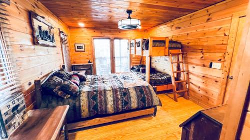 a bedroom with a bed in a wooden cabin at Virtue Vacations - Cabin & Cottage in Blue Ridge