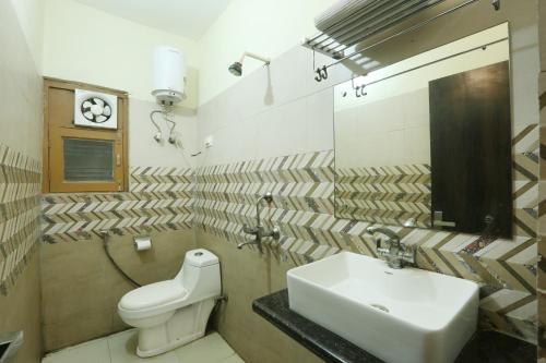 a bathroom with a sink and a toilet at Hotel Lemon Suites in Noida