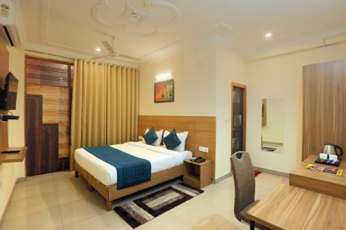 Cette chambre comprend un lit et un bureau. dans l'établissement Hotel Lemon Suites, à Noida