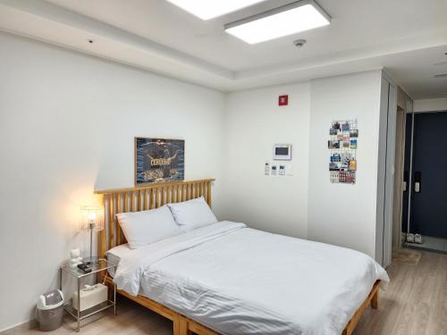 a bedroom with a large bed with white sheets at Sokcho Summitbay 1708 "Ocean View" in Sokcho
