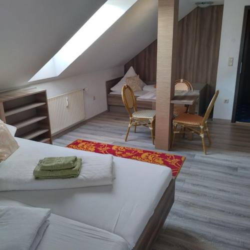 a bedroom with a bed and a table and chairs at Pension Goldenes Vogtland in Adorf
