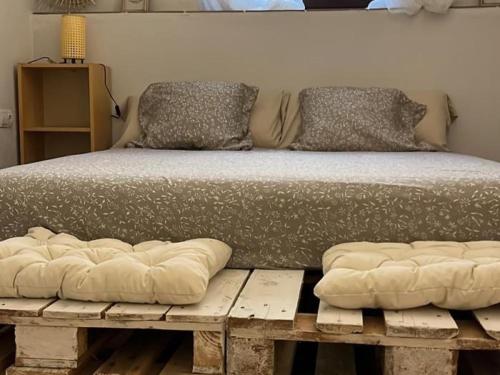 - un lit sur une plate-forme en bois avec 2 oreillers dans l'établissement Reconnectar Ca La Noni, à Calonge