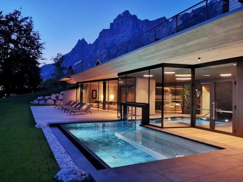 una casa con piscina frente a ella en Parkhotel Ladinia, en San Vito di Cadore